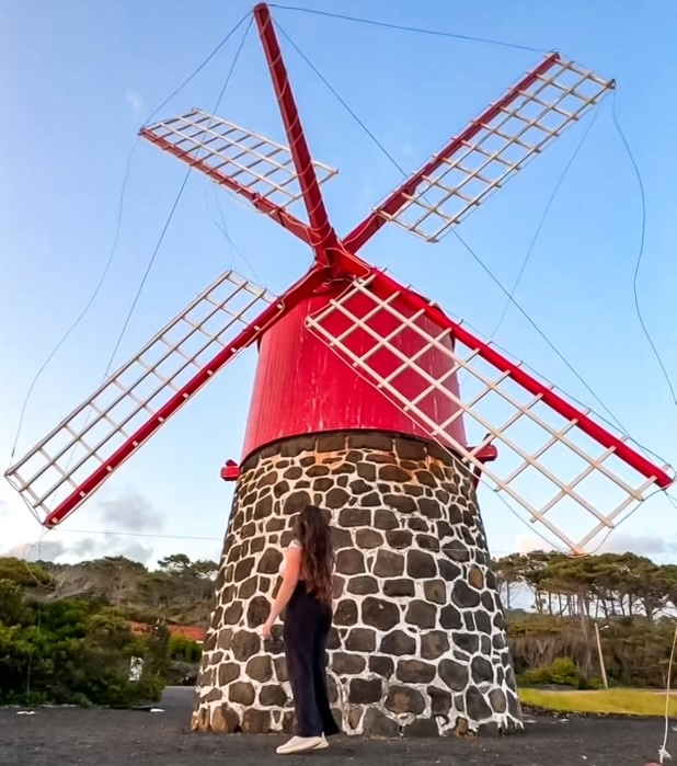 Elaina looking up at a red windmill in Pico, Azores