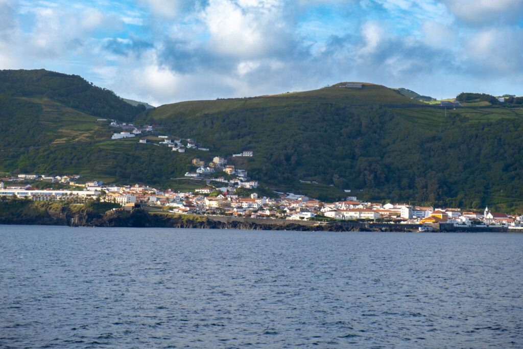 View of Velas, Sao Jorge from the ferry between Sao Jorge and Pico islands in the Azores. The main part of the village is on a low area, just above the port, while part of the village snakes up the side of the mountain. 