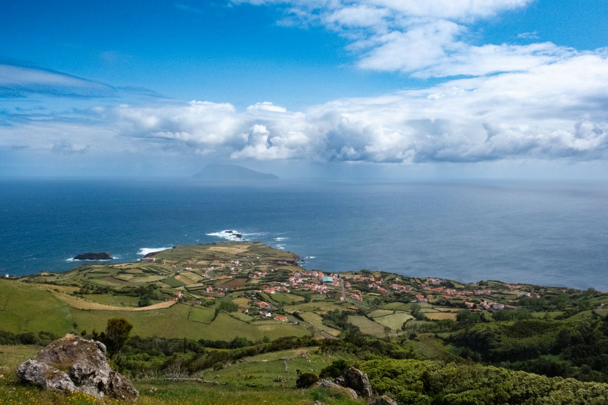 View over a small village on Flores island looking out at Corvo island in the distance