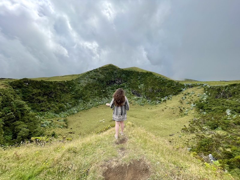 Elaina standing at the edge of a caldeira looking out over it. 