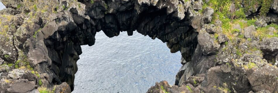 Elaina standing in front of the Arco Natural de Velas on Sao Jorge