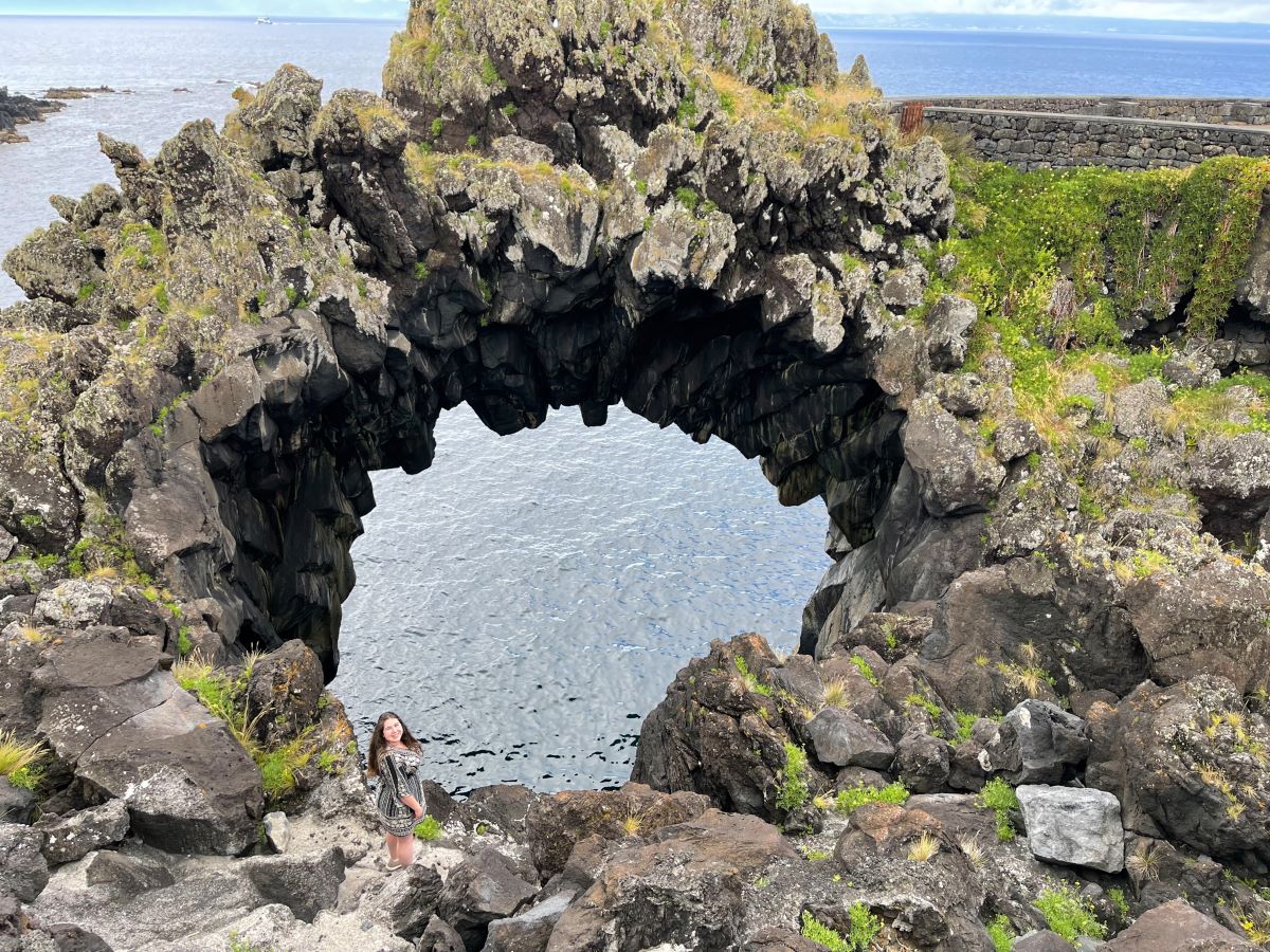 Elaina standing in front of the Arco Natural de Velas on Sao Jorge