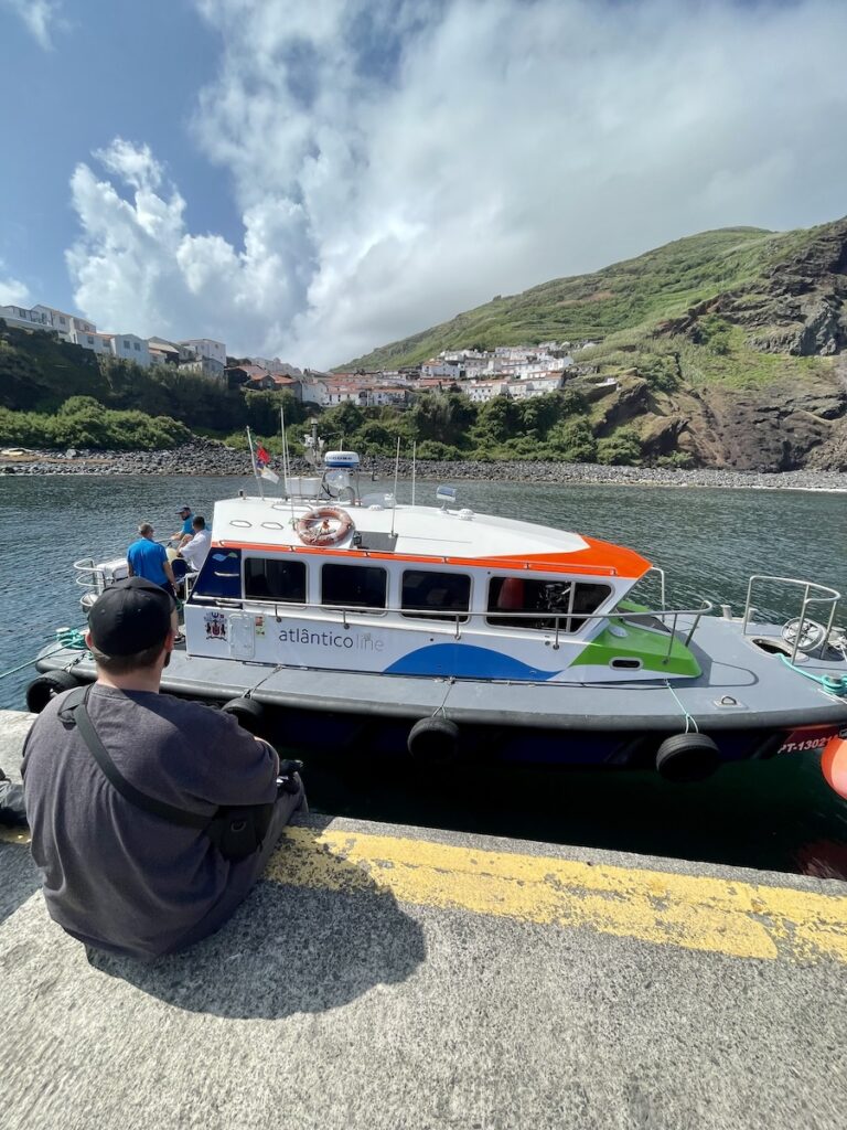 Zac sitting on the dock with the Atlanticoline boat preparing to travel from Corvo to Flores