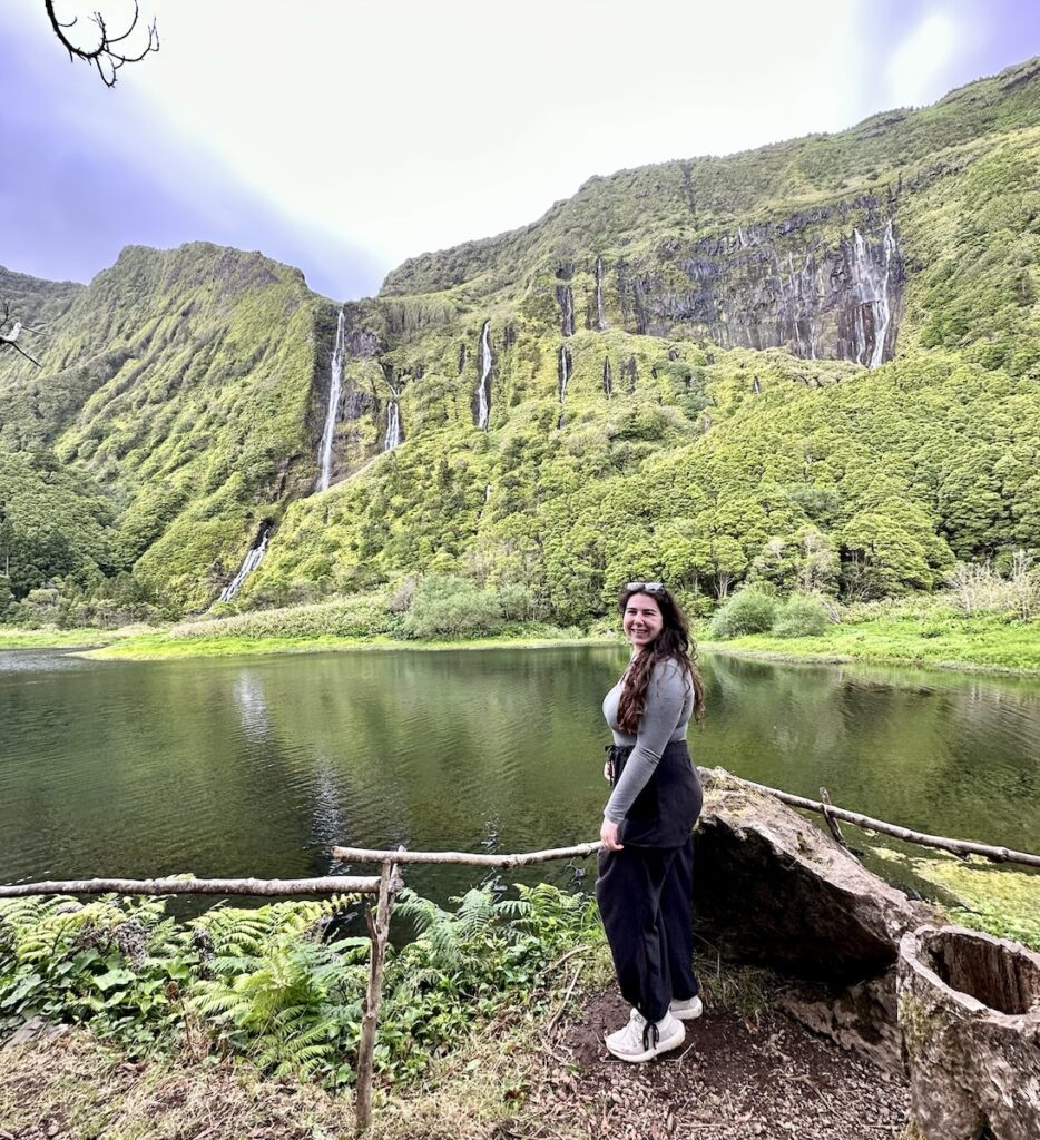 Elaina standing in fromt of Cascata da Ribeira do Ferreiro in Flores, Azores